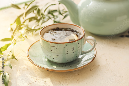 Cup of hot green tea on lig...