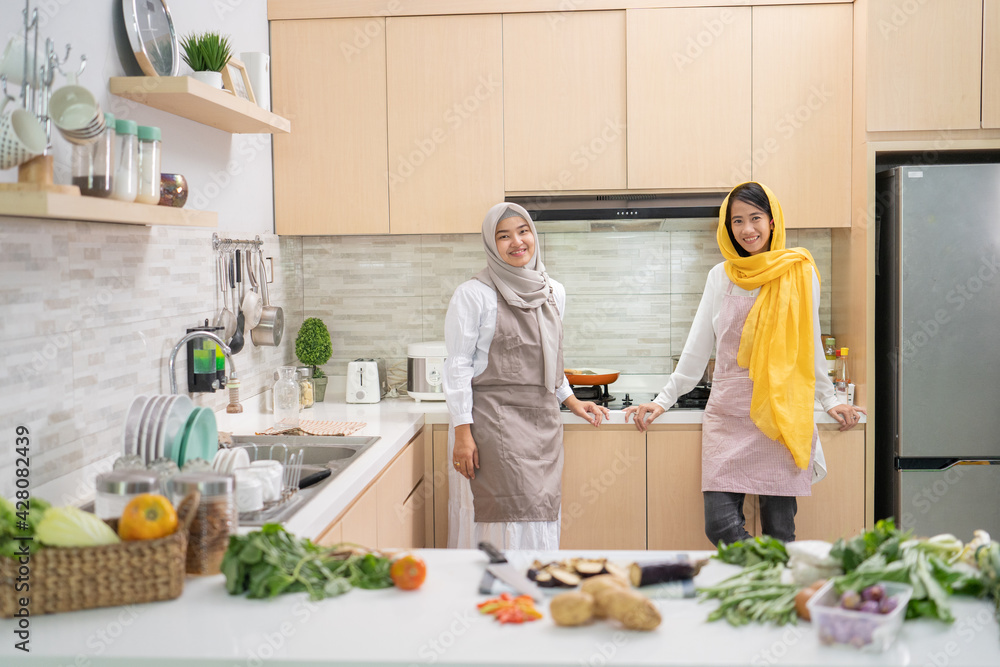 beautiful two muslim woman enjoy cooking dinner together for iftar breaking the fast on ramadan in the kitchen