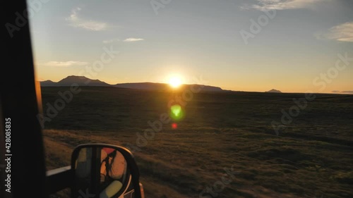 Volcanic Icelandic landscape with sunset producing lens flare, Wide panorama driving shot photo