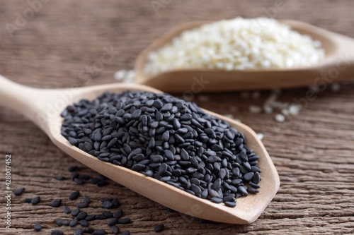 Close up,Black sesame (Poppy) and white sesame seeds in wooden spoon on wooden background,copy space.