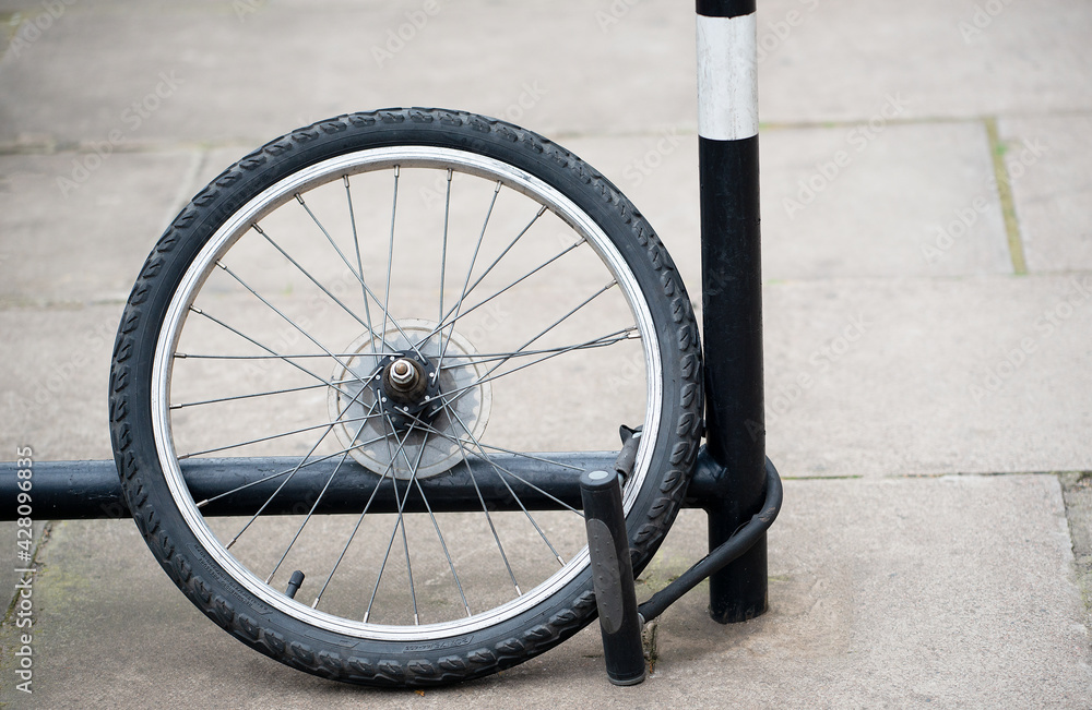 Bicycle Theft Rear wheel of bicycle with lock attached to bike rack. All that remains after the bicycle was stolen. Stock Photo Adobe Stock