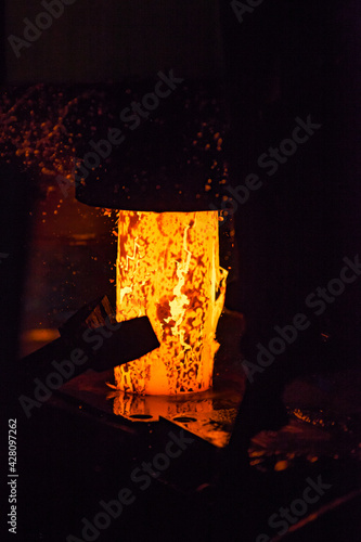 Production of bearing rings on a mechanical press. Red-hot metal cylinder with slag oxides.