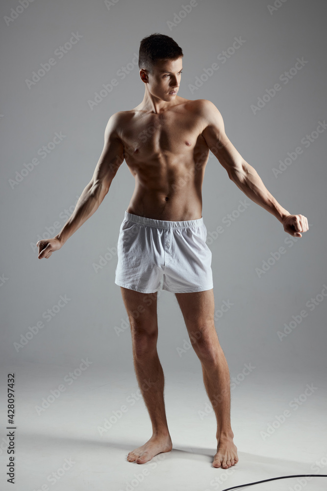 an athlete in shorts gestures with his hands in a bright room an athlete in shorts gestures with his hands in a bright room