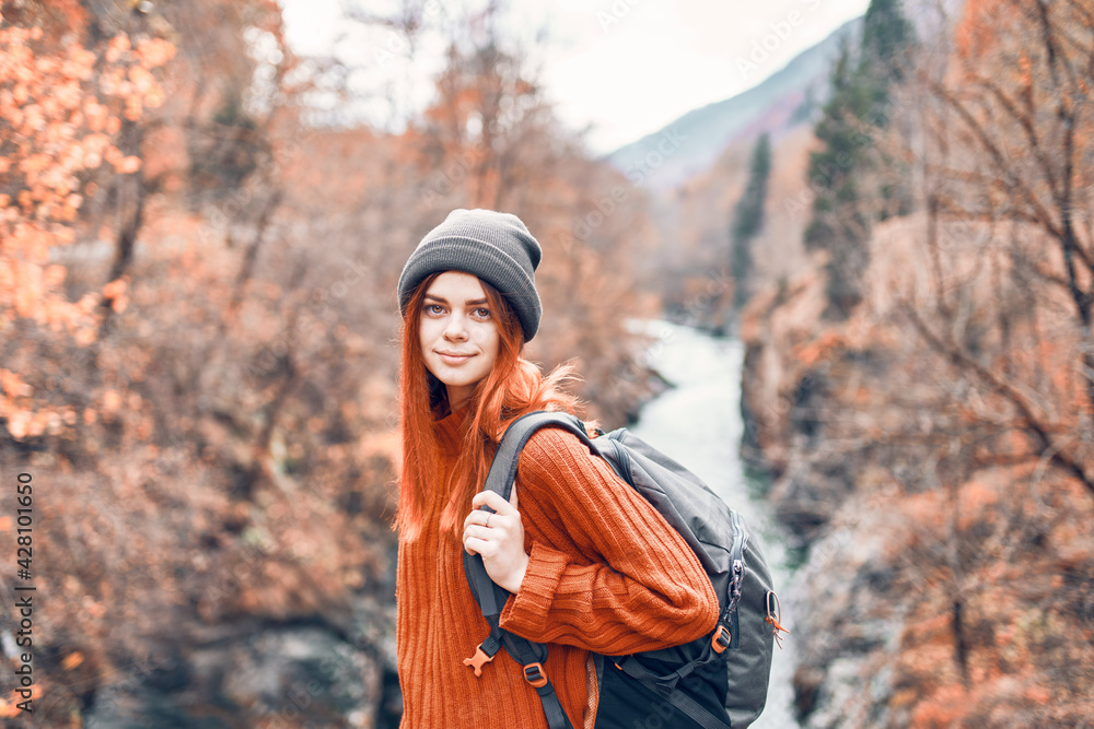 woman stands on a bridge over a river in the mountains Autumn forest travel woman stands on a bridge over a river in the mountains Autumn forest travel