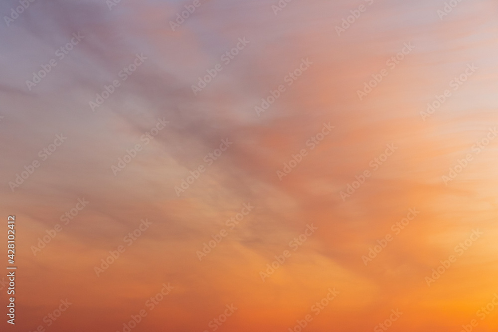 Colorful sunset sky. Beautiful orange natural clouds background in the light of the setting sun