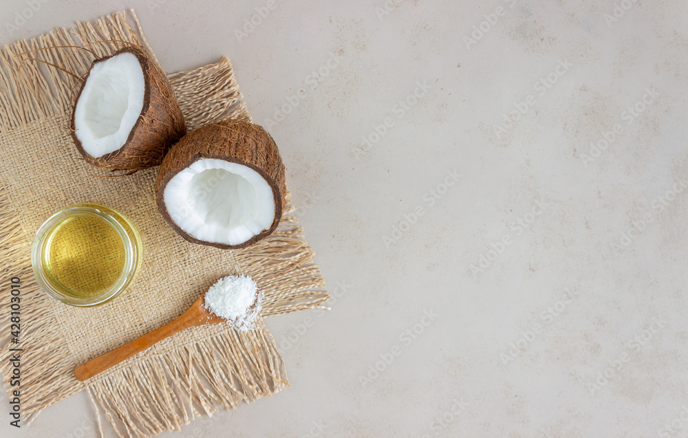 Coconut oil in a jar and fresh coconuts on a beige background. Natural cosmetics. Coconut oil in a jar and fresh coconuts on a beige background. Natural cosmetics.
