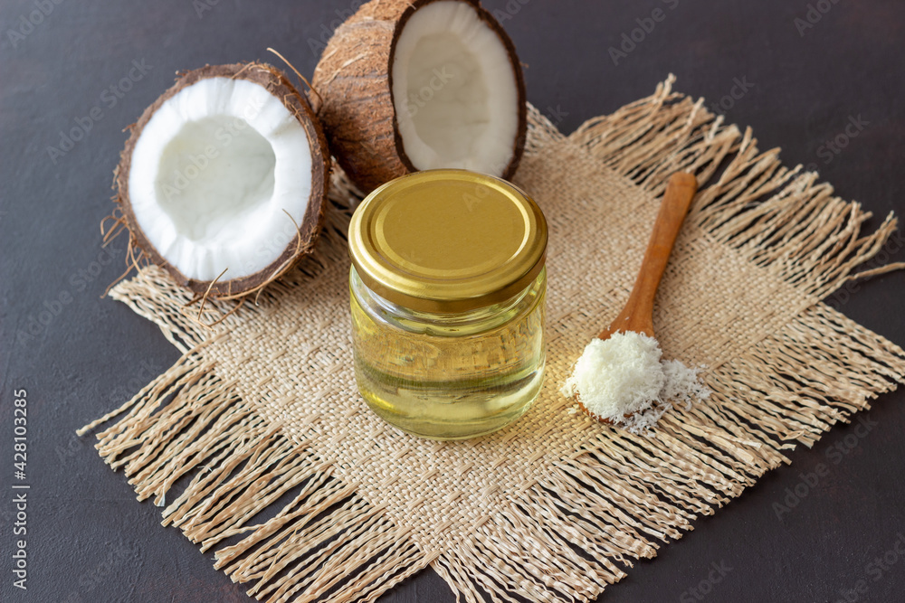 Coconut oil in a jar and fresh coconuts on a beige background. Natural cosmetics. Coconut oil in a jar and fresh coconuts on a beige background. Natural cosmetics.