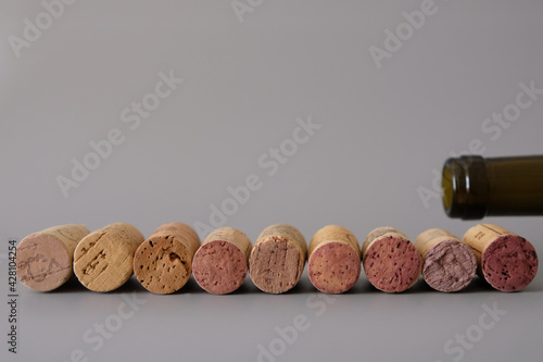 A number of natural wine corks on a gray background. Blurred bottle throat. Copy space.