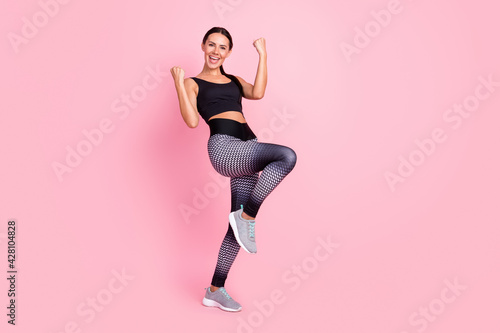 Fototapeta Naklejka Na Ścianę i Meble -  Full size photo of happy young charming lady raise hands champion sport isolated on pink color background