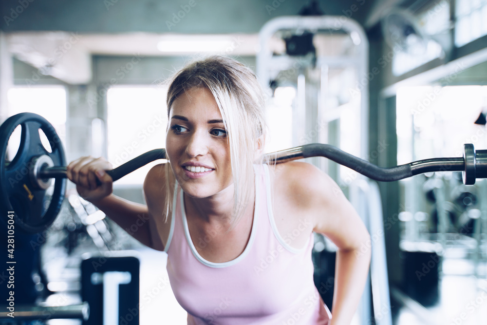 Obraz premium Sport women lift up barbell in fitness gym