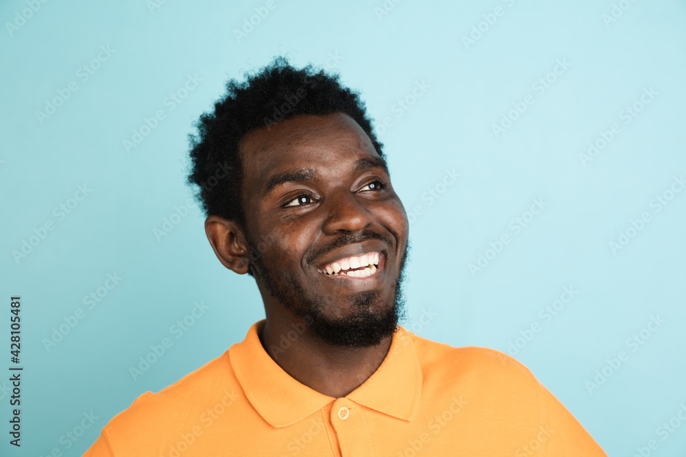 African man's portrait isolated over blue studio background with copyspace African man's portrait isolated over blue studio background with copyspace