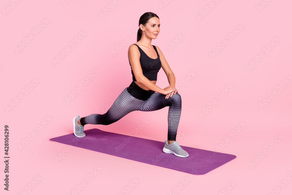 Photo of charming strong young lady sportswear doing exercises stretching looking empty space isolated pink color background Photo of charming strong young lady sportswear doing exercises stretching looking empty space isolated pink color background