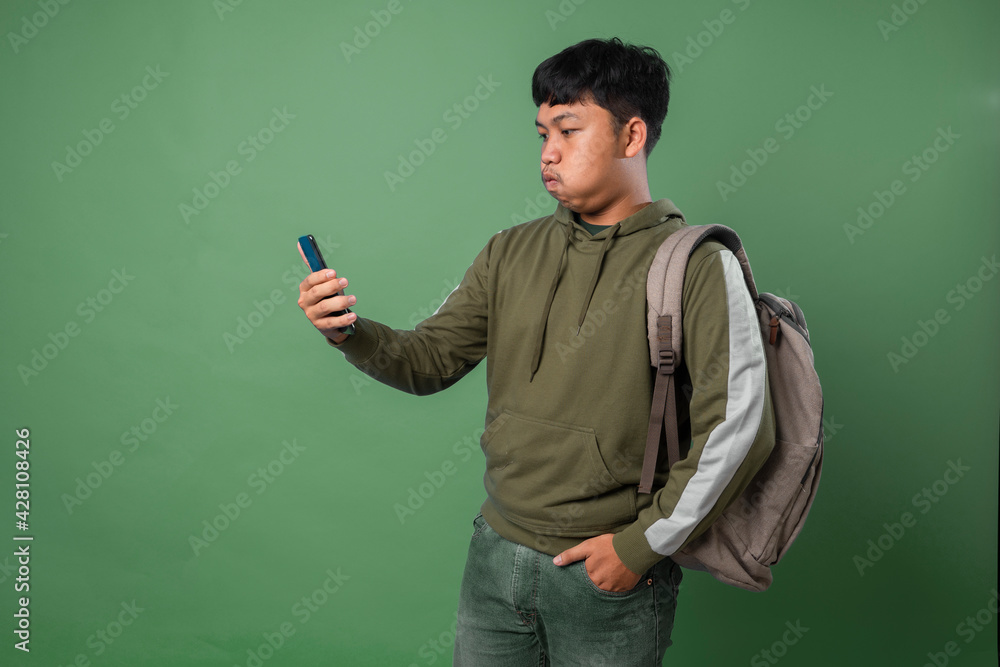 Asian young man feels hate and disgusted with what show on the smartphone. Asian young man feels hate and disgusted with what show on the smartphone.