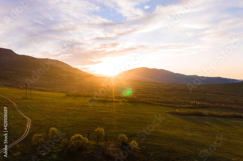 low mountains and pastures in the Carpathian village, landscape at sunset, Ukrainian Carpathians and agricultural fields, trails in the mountains and fields.