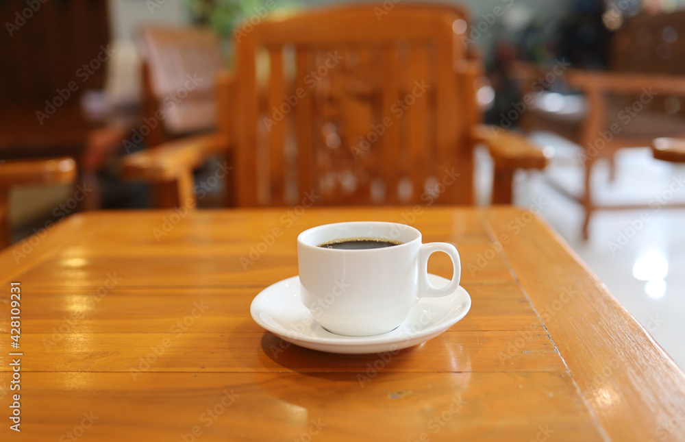 A black-and-white coffee cup was placed on a golden teak table placed in a hotel breakfast zone after the opening of tourism after a covid-19 interruption.
