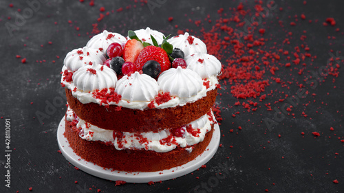 Delicious homemade red velvet cake with meringue and mascarpone cream on black background.
