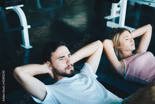 Personal couple trainer doing sit ups in gym..