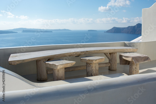 Volcano and caldera view from a balcony in Oia village, Santorini island, Greece. Sunny day, calm sea.