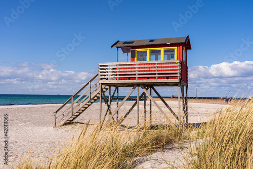 Popular white sand beach with turquoise water and lifeguard tower on the south western tip of Sweden.
