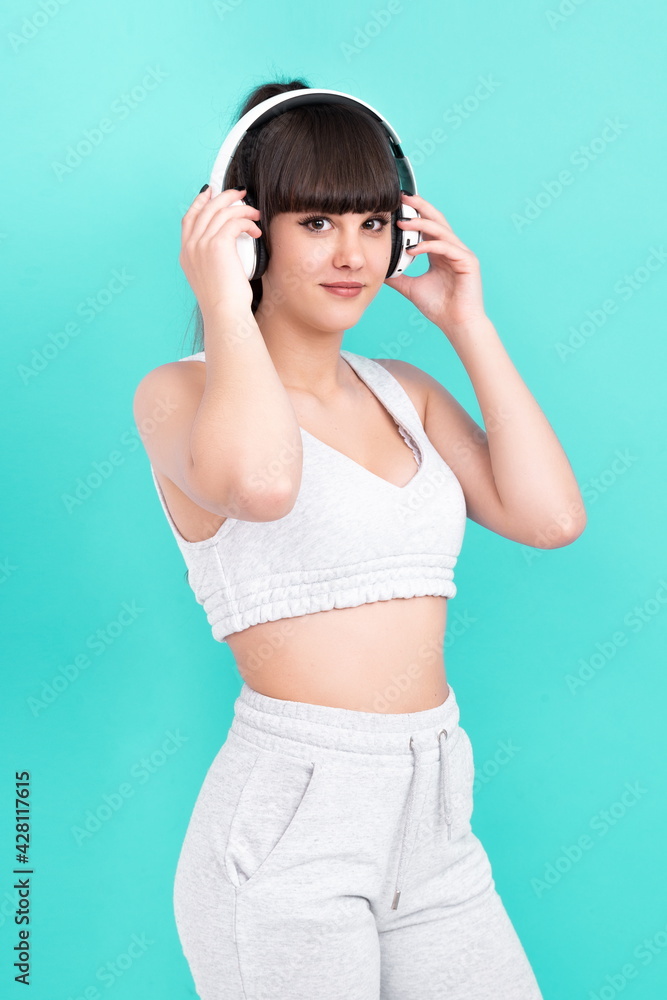Woman with headphones on blue background happy enjoying with music
