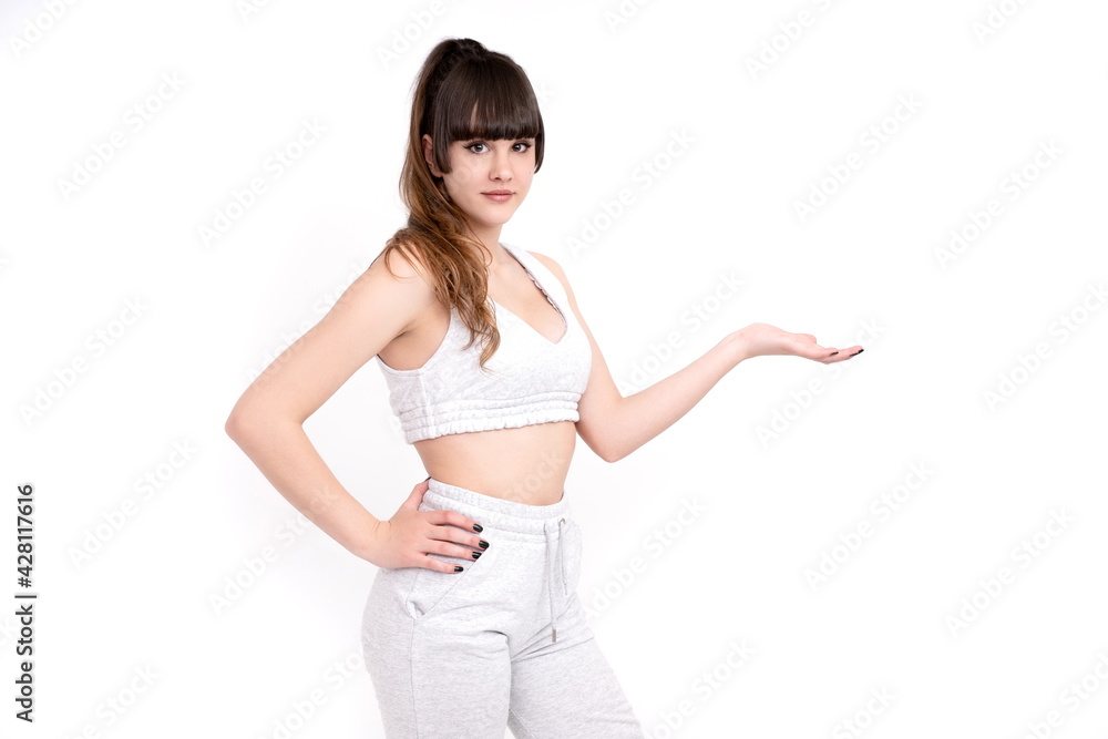 Woman on white background looking at camera and with palm up as holding something - obrazy, fototapety, plakaty 