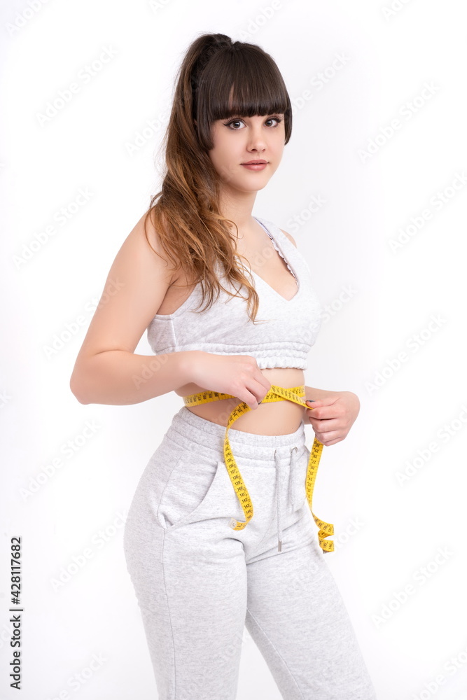 young woman measuring waist on white background young woman measuring waist on white background