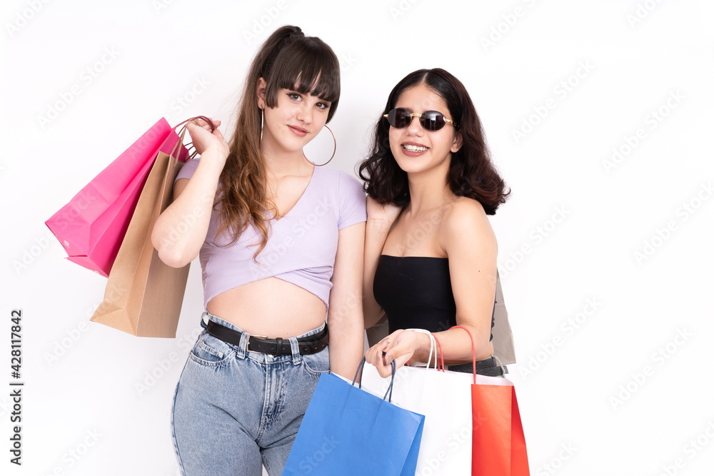 Two girlfriends with shopping bags on white background Two girlfriends with shopping bags on white background