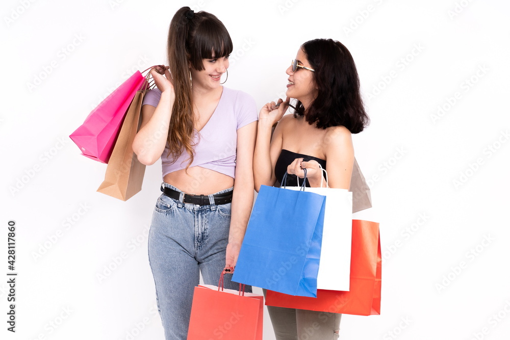 Two girlfriends with shopping bags on white background