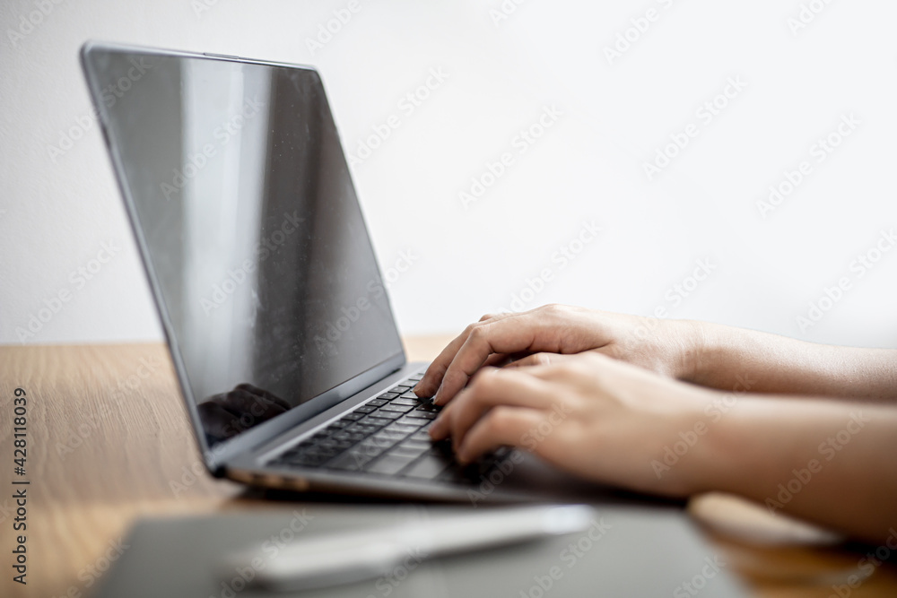 Close-up of a business woman typing on a laptop keyboard, a business woman using a laptop to chat with a partner via a messaging application. Concept of using technology in communication. Close-up of a business woman typing on a laptop keyboard, a business woman using a laptop to chat with a partner via a messaging application. Concept of using technology in communication.