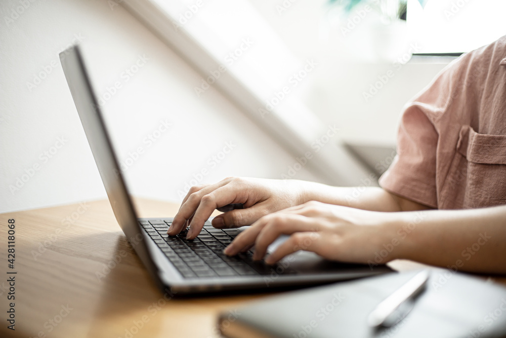 Close-up of a business woman typing on a laptop keyboard, a business woman using a laptop to chat with a partner via a messaging application. Concept of using technology in communication. Close-up of a business woman typing on a laptop keyboard, a business woman using a laptop to chat with a partner via a messaging application. Concept of using technology in communication.