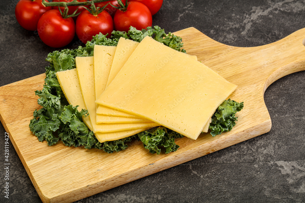 Sliced Gauda cheese over board Sliced Gauda cheese over board