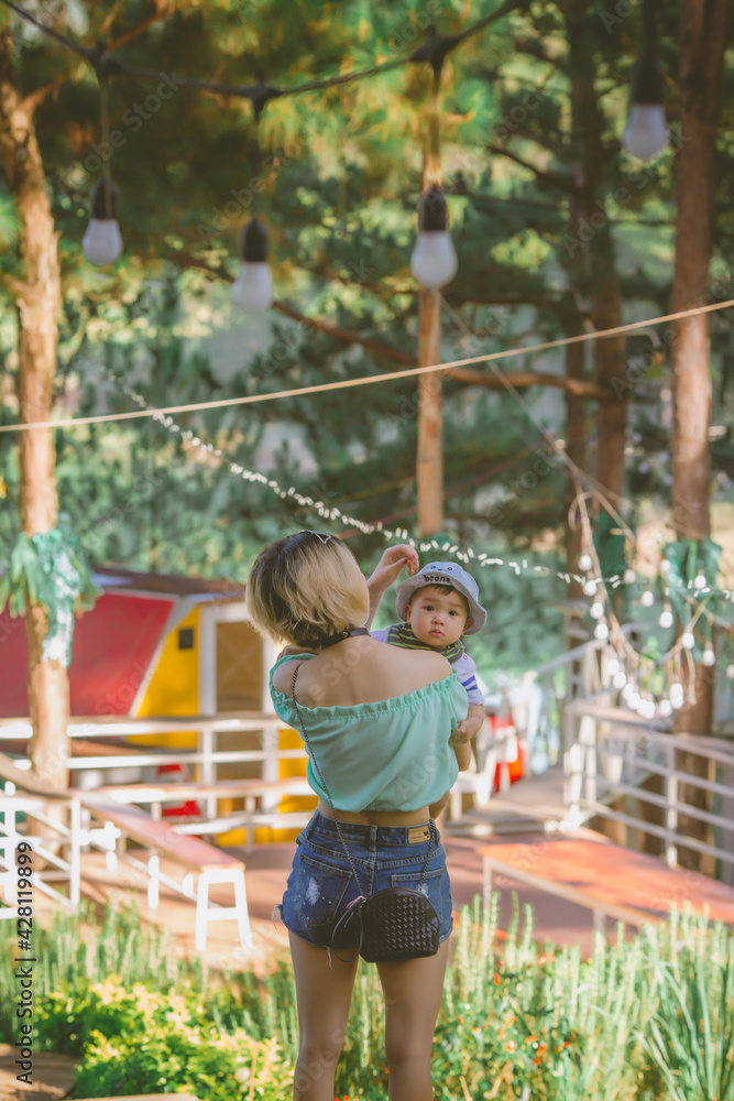 Mother holding cute baby while taking a walk Mother holding cute baby while taking a walk