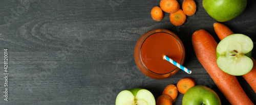 Glass of juice and ingredients on dark wooden background
