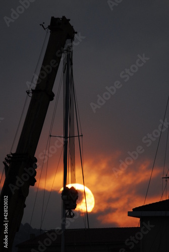 Fototapeta Naklejka Na Ścianę i Meble -  Gru del cantiere al tramonto
