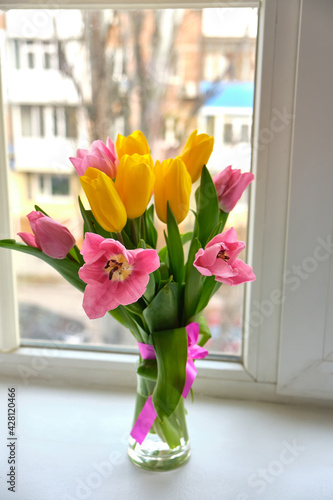 Large multicolored tulips on a white window