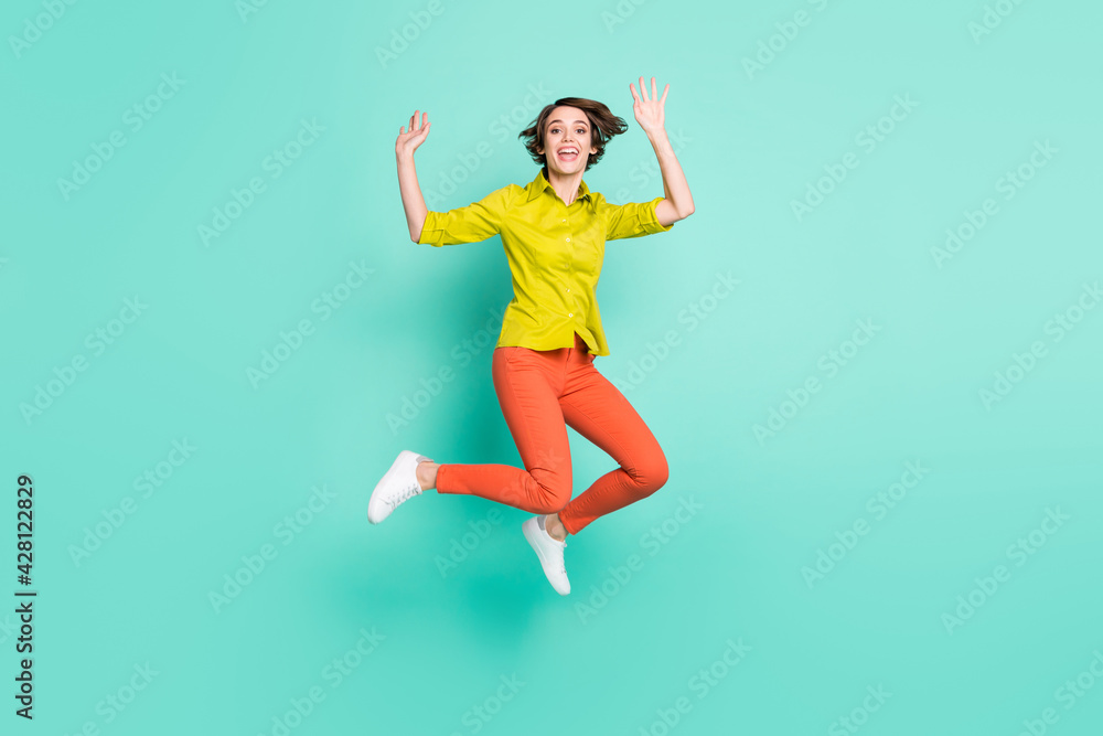 Full length body size photo of jumping high woman waving hands greeting cheerful isolated bright turquoise color background