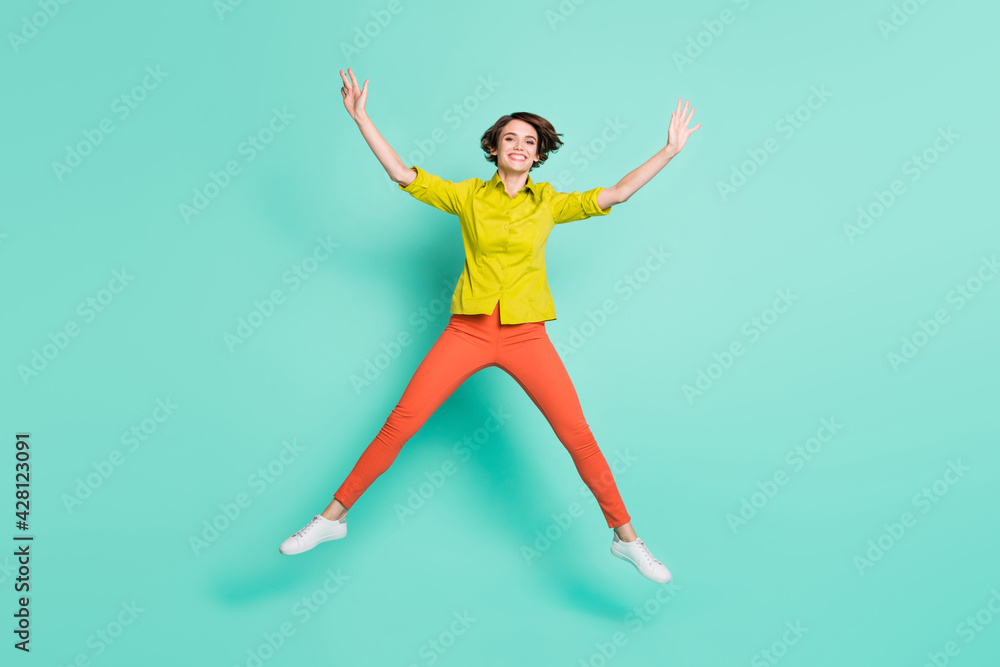 Full length body size photo of smiling girl playful childish jumping like star isolated vibrant teal color background