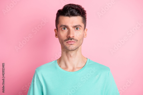 Portrait of young handsome serious man with brown hair and mustache look camera isolated on pink color background © deagreez