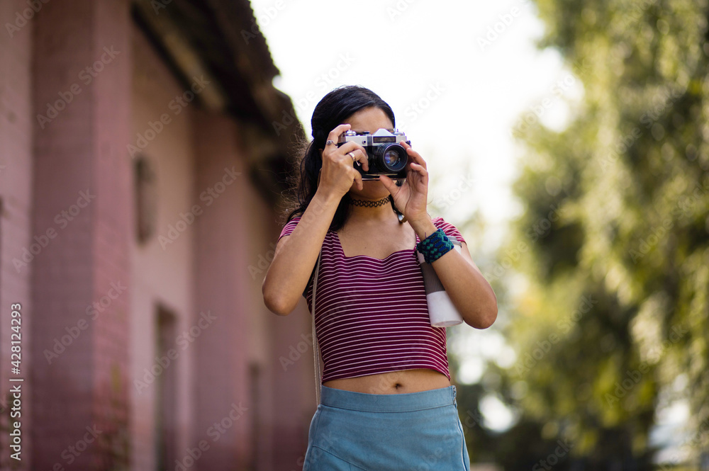 Girl on street taking photo.
