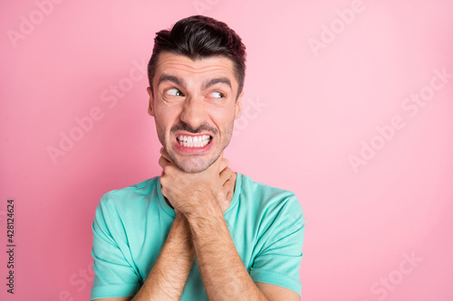 Photo of young unhappy aggressive angry furious man look copyspace choke himself isolated on pink color background