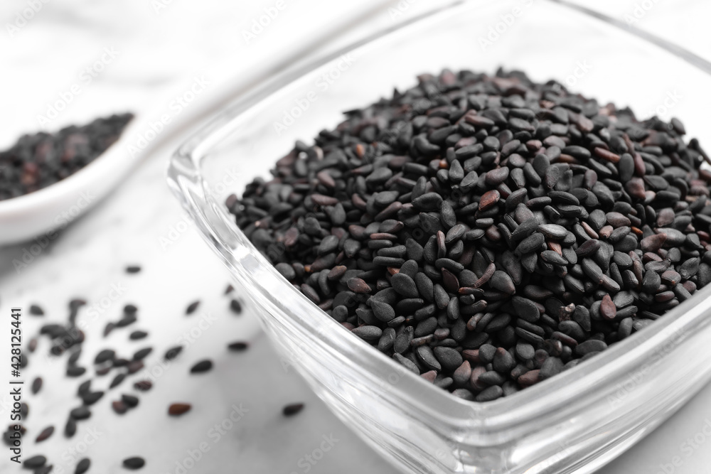 Black sesame seeds on white table, closeup Black sesame seeds on white table, closeup
