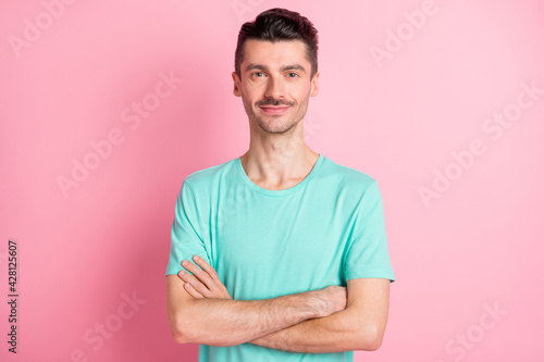 Photo of young happy positive smiling cheerful man with mustache and crossed hands isolated on pink color background