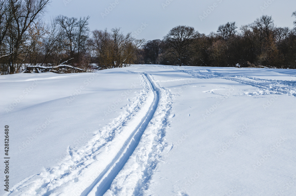 Ski trail near the town where people people skiing. Ski tracks Ski trail near the town where people people skiing. Ski tracks