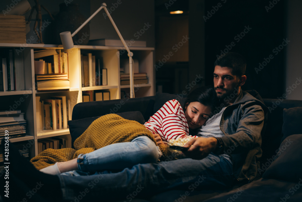 young couple watching television together at home