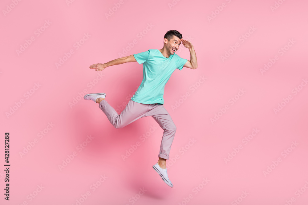 Full length photo of young man happy positive smile jump look ahead isolated over pastel color background