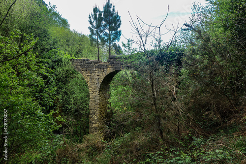 San Sebastian, Spain - April 15, 2021: Ancient stone Aquaduct on a coastal path in the Basque country