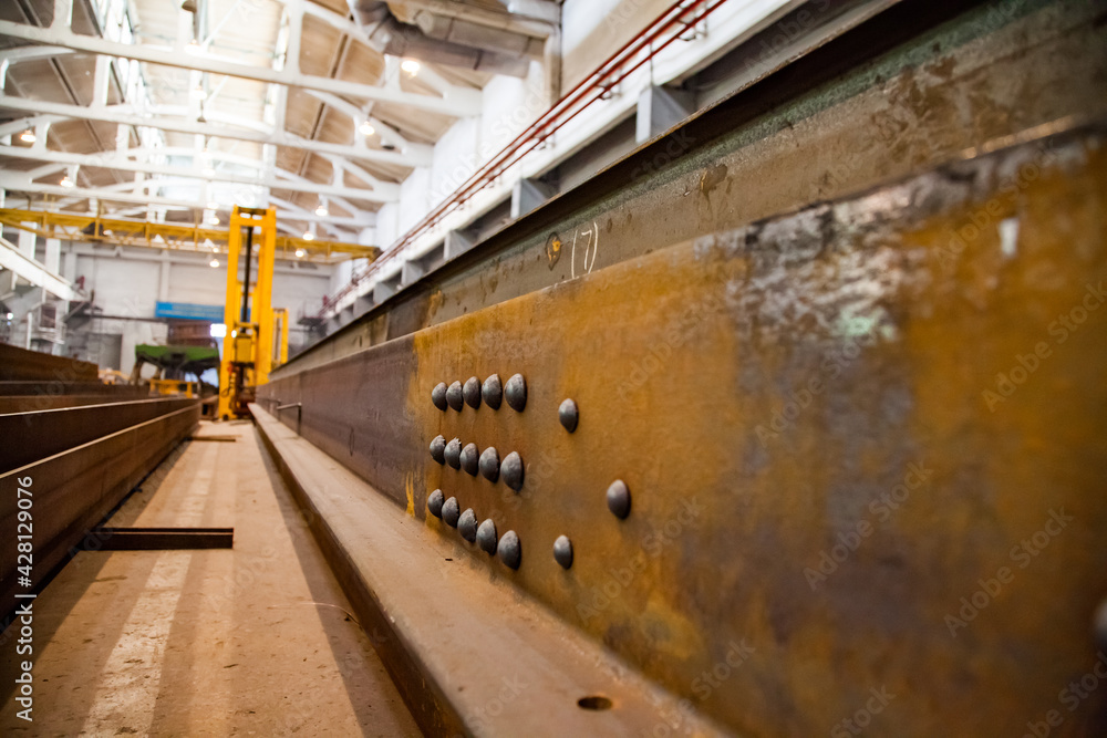 Train car-building plant. View on large steel detail with rivets ...