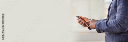 Businessman using smart phone in blurred office space background and copy space.Concept of business people use technology. Close up of a man using mobile smart phone. Banner