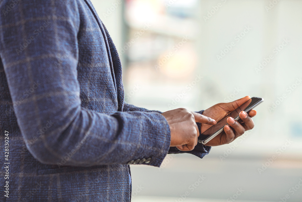 Close up of a business man using mobile smart phone, background for copy.. Using smart phone. Close-up image of male hands using smartphone, searching or social networks concept