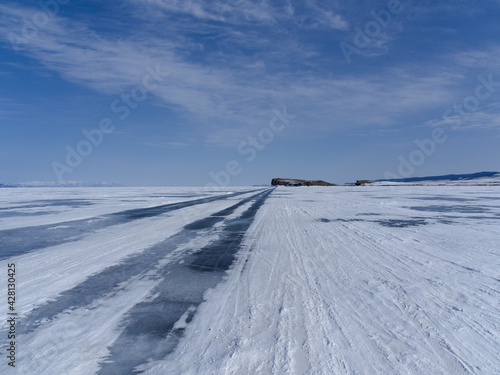 a road going into the distance on the ice of Lake Baikal along the island of Olkhon. Winter Siberia Russia